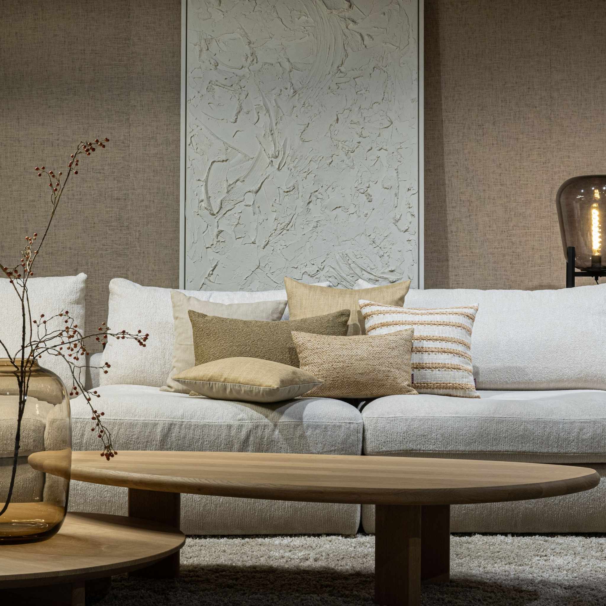 Luxe zandkleurige sierkussens op een lichte bank